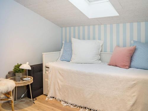 a bedroom with a bed with blue and white stripes at Holiday home Thisted LIII in Thisted