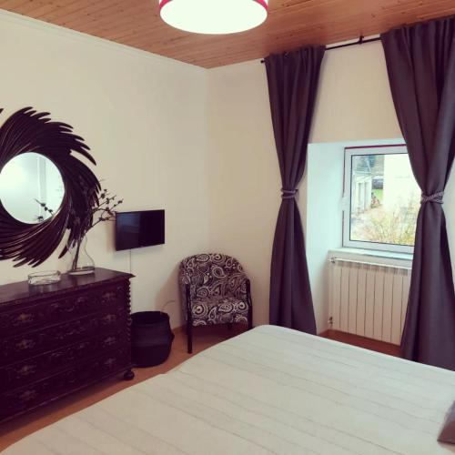 a bedroom with a bed and a chair and a mirror at Sotam Country House EN342 in Góis