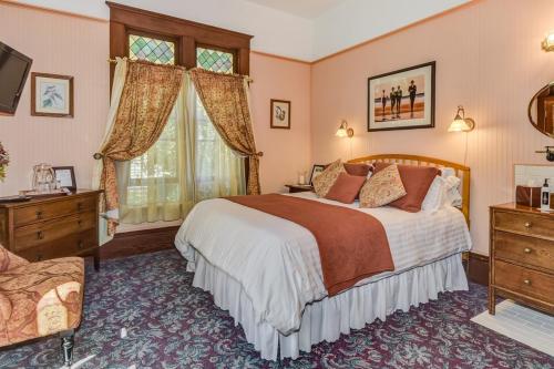 a bedroom with a large bed and a window at The KirkHouse Bed and Breakfast in Friday Harbor