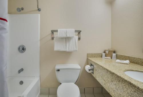 La salle de bains est pourvue de toilettes blanches et d'un lavabo. dans l'établissement Red Roof Inn & Suites Knoxville East, à Knoxville
