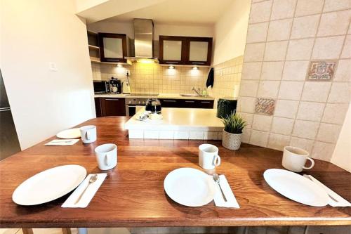 eine Küche mit einem Holztisch mit weißen Platten darauf in der Unterkunft Exclusive PENTHOUSE near CityCenter 120m2 +NETFLIX in Krakau