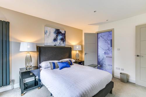 sypialnia z dużym białym łóżkiem z niebieskimi akcentami w obiekcie Valley house w mieście Biggin Hill