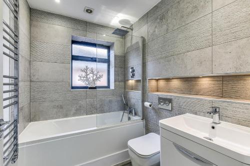 a bathroom with a tub and a toilet and a sink at Valley house in Biggin Hill
