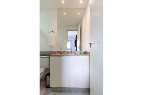 VA26 - Apartamento Luxuoso com Varanda Gourmet na Vila Carrão في ساو باولو: حمام أبيض مع حوض ومرآة