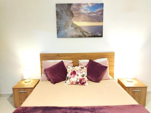 a bedroom with a bed with purple pillows at Modern, spacious and bright apt in centre of Malta in Mosta