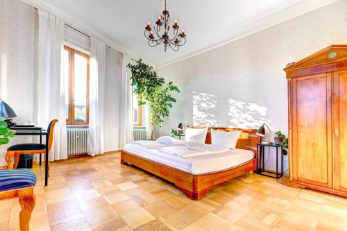 ein Schlafzimmer mit einem großen Bett und einem Schreibtisch in der Unterkunft Hotel Villa Königsgarten in Siebeldingen