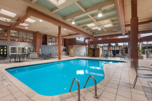 a pool at a hotel with tables and chairs at Best Western St Catharines Hotel & Conference Centre in St. Catharines