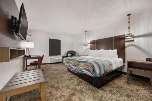 una camera d'albergo con letto e scrivania di SureStay Hotel By Best Western Tuscaloosa Southeast a Tuscaloosa
