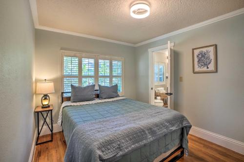 1 dormitorio con 1 cama con edredón azul y ventana en Waterfront Port Richey Getaway with Shared Dock, en Port Richey