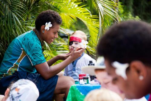 a woman with flowers on her head and a group of people at Outrigger Fiji Beach Resort in Korotogo