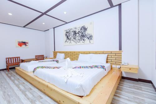 twee bedden in een kamer met witte muren bij Saline Hot Spring Resort นำ้พุร้อนเค็ม รีสอร์ท 