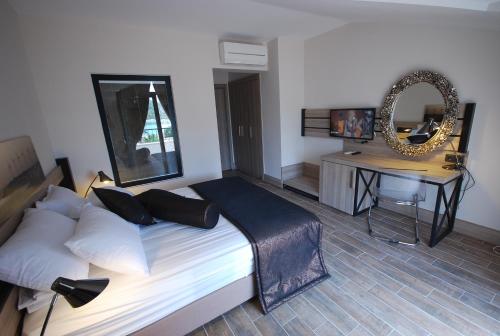 a bedroom with a bed and a table with a mirror at S3 Seahorse Beach Club in Oludeniz
