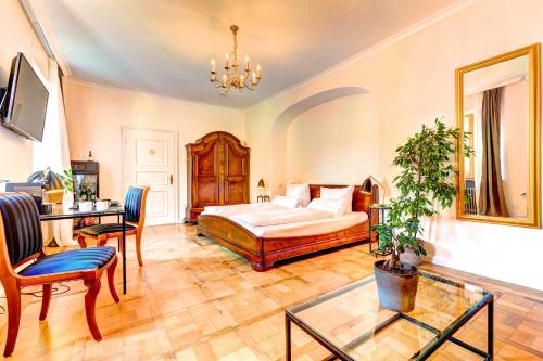 a bedroom with a bed and a table and chairs at Hotel Villa Königsgarten in Siebeldingen