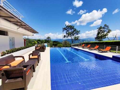 a swimming pool with lounge chairs and a resort at CasaMIA Hotel Boutique - Villeta in Villeta