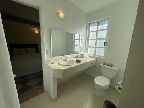 uma casa de banho com um lavatório, um WC e um espelho. em Hotel Real Home em Tula de Allende