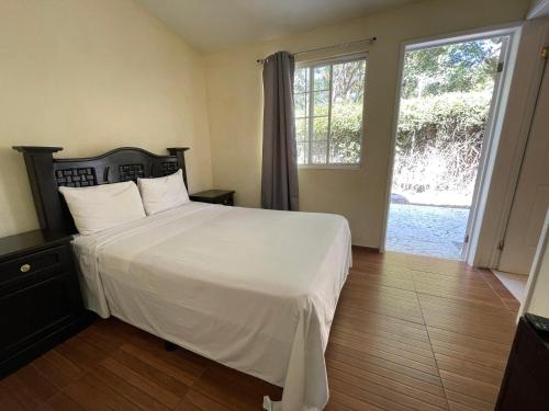 um quarto com uma cama branca e uma grande janela em Hotel Real Home em Tula de Allende