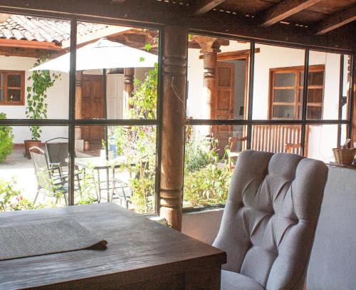 a table with a chair and an umbrella on a patio at Noma Bed & Breakfast in San Cristóbal de Las Casas