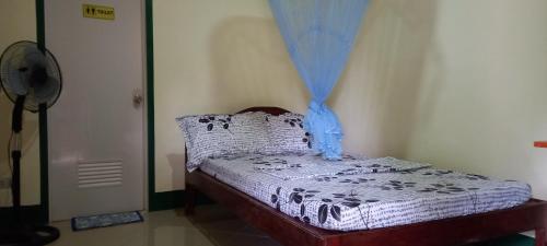 ItaytayにあるRodel Yellow Hauzの青いカーテンが備わるドミトリールームの小さなベッド1台分です。
