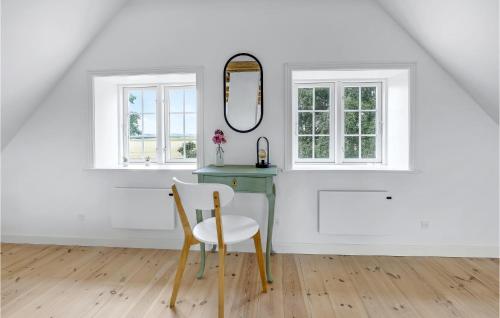 a white room with a chair and a mirror at Beautiful Home In Svaneke With Kitchen in Svaneke