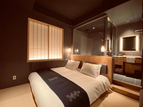 a bedroom with a bed with a window and a sink at Hotel Zagakukan in Hakone