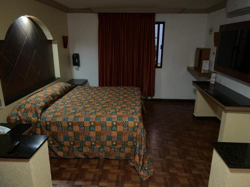 um quarto de hotel com uma cama e uma televisão de ecrã plano em Hotel Xiada em San Francisco del Rincón