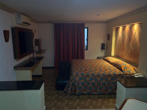 um quarto de hotel com uma cama e uma televisão em Hotel Xiada em San Francisco del Rincón