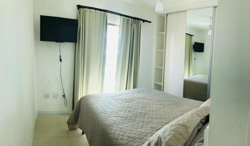 1 dormitorio con cama y ventana grande en Amplo Apartamento 200m da Praia do Forte- SEM ROUPA DE CAMA E BANHO, en Cabo Frío