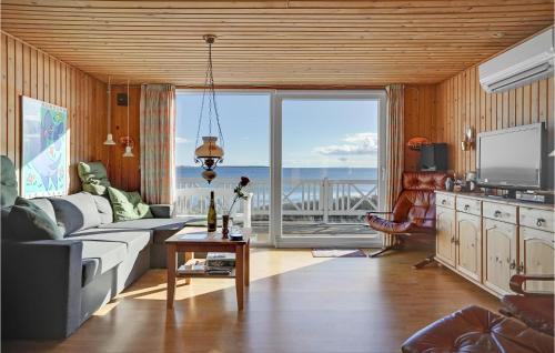a living room with a couch and a large window at 2 Bedroom Gorgeous Home In Ebeltoft in Ebeltoft