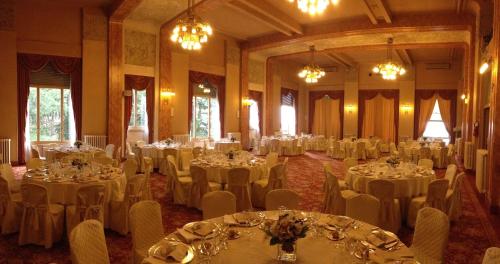 a banquet hall with white tables and chairs at Palace Grand Hotel Varese in Varese