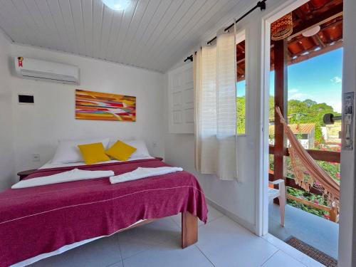 a bedroom with a bed and a balcony at Pousada Aconchego in Morro de São Paulo