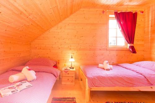Cette chambre en bois comprend 2 lits jumeaux et une fenêtre. dans l'établissement Holiday house with a parking space Ravna Gora, Gorski kotar - 20300, à Ravna Gora