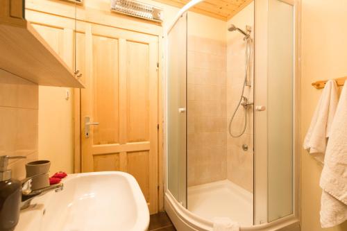La salle de bains est pourvue d'une douche et d'une baignoire blanche. dans l'établissement Holiday house with a parking space Ravna Gora, Gorski kotar - 20300, à Ravna Gora