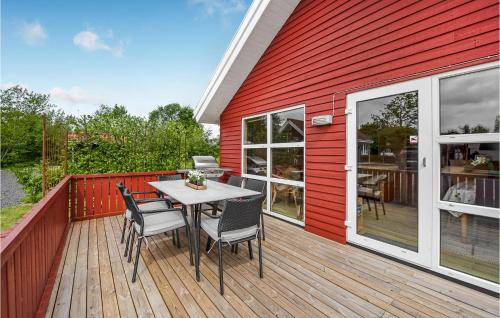 eine Holzterrasse mit einem Tisch und Stühlen darauf in der Unterkunft 2 Bedroom Nice Home In Hemmet in Hemmet