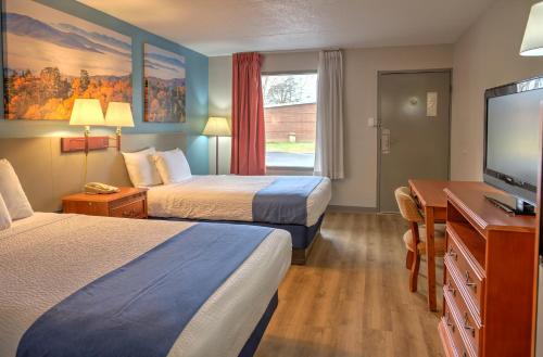 a hotel room with two beds and a flat screen tv at Days Inn by Wyndham Harriman in Harriman