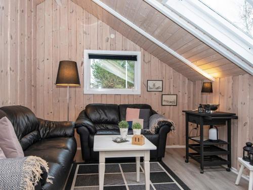 a living room with a leather couch and a table at 6 person holiday home in Hemmet-By Traum in Hemmet