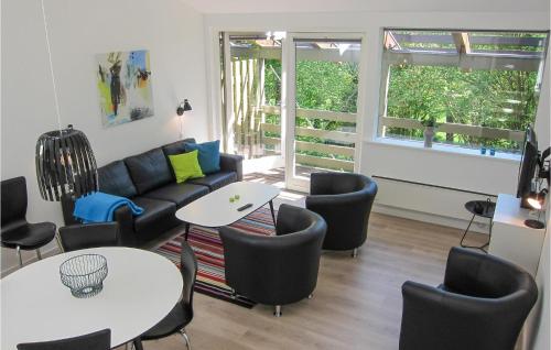a living room with a couch and tables and chairs at 2 Bedroom Stunning Apartment In Allinge in Allinge