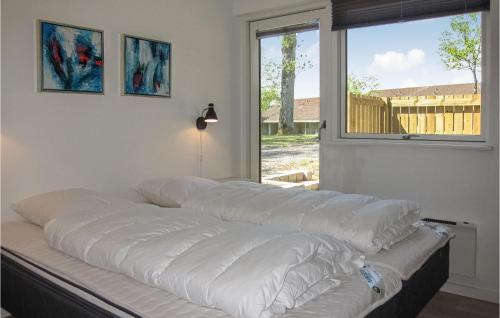 a bed with white sheets in a room with a window at 2 Bedroom Stunning Apartment In Allinge in Allinge