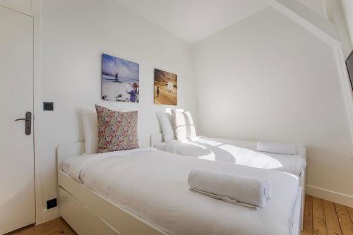 deux lits dans une chambre aux murs blancs dans l'établissement La Villa Suzanne - Two Bedrooms - Deauville Beach, à Deauville