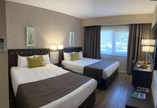 a hotel room with two beds and a window at Days Inn Zarate in Zárate
