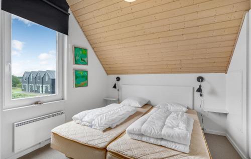 two beds in a room with a wooden ceiling at Lovely Home In Nrre Nebel With Wifi in Nørre Nebel