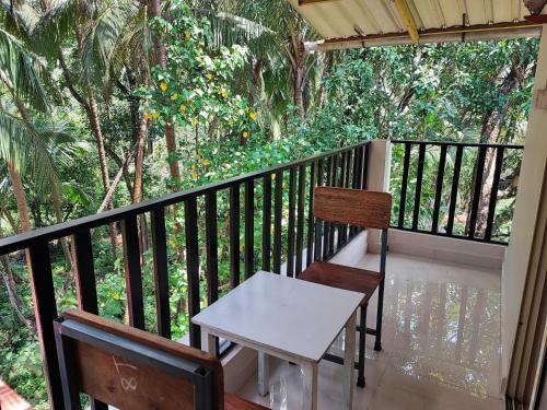 a porch with two chairs and a table on a balcony at Shivam Bnb Mandrem Resort in Mandrem