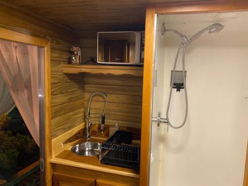uma cozinha com um lavatório e um chuveiro em Chale Sobre Rodas e Spa Exclusive - Localizado Próximo do Centro em Canela
