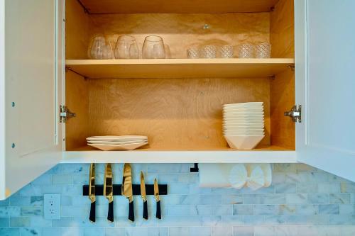 a cupboard with plates and utensils in it at Luxury Old Town Scottsdale Home with Pool King Bed & Putting Green - Casa Gram in Scottsdale