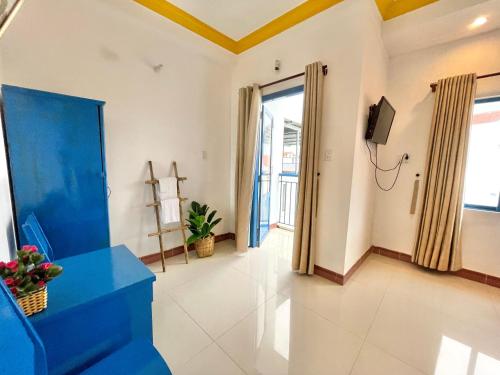 sala de estar con sofá azul y TV en Hi Hợp Yến Homestay, en Hoi An