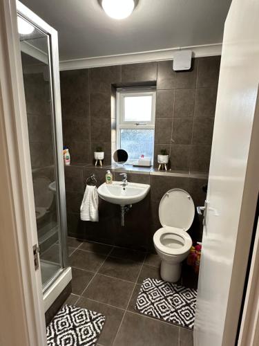La salle de bains est pourvue de toilettes et d'un lavabo. dans l'établissement Stylish 1 Bedroom close to Tooting Bec Station, à Londres