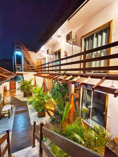 a building with a balcony with plants and tables at Pousada Origin in Guarda do Embaú