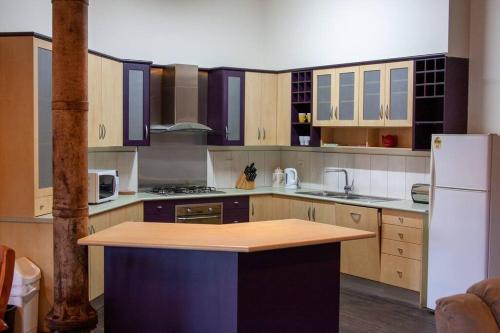 cocina con armarios de madera y encimera de madera en 1885 Warehouse Apartment, en Tumbarumba