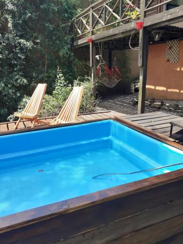 une piscine avec 2 chaises longues et une piscine dans l'établissement Cabaña Sierra, à Sierra de los Padres