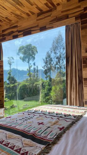 a bedroom with a large window with a bed in front at La Jempana Kintamani in Kintamani