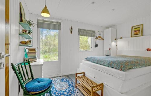 um quarto com uma cama, uma cadeira e uma janela em 1 Bedroom Lovely Home In Nibe em Nibe